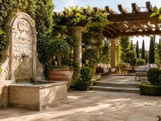A beautifully landscaped Tuscan style backyard garden with large terracotta planters and a stone patio