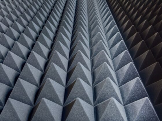 featured image - The Effectiveness of Different Floor Soundproofing Materials Floor soundproofing is a crucial aspect of modern construction, aiming to minimize the transmission of sound between different levels of a building. The effectiveness of floor soundproofing hinges largely on the materials used, each possessing unique properties that influence their sound dampening capabilities. Traditional materials, like mass-loaded vinyl (MLV) and acoustic foam, have long been staples in the industry. MLV, known for its density and mass, effectively blocks airborne noise, while acoustic foam, with its open-cell structure, excels in absorbing sound waves. Recent years have seen the emergence of more innovative materials, such as green glue and soundproof underlayment, offering both sound insulation and environmental benefits. As we delve deeper into these materials, it's crucial to understand their composition, mechanism of action, and suitability for different types of floors, be it concrete or wooden structures. The Role of Density in Floor Soundproofing Density plays a pivotal role in floor soundproofing, acting as the primary barrier against noise transmission. Heavier materials, like MLV, leverage their mass to reflect and absorb sound waves, making them highly effective against a range of frequencies. On the other hand, lighter materials, such as cork or rubber underlayment, while less effective in blocking lower frequencies, offer excellent vibration dampening properties. This is particularly important in scenarios where foot traffic or machinery causes structural noise. The comparison between these materials demonstrates a fundamental trade-off in soundproofing: the heavier the material, the better its sound-blocking capabilities, but at the cost of increased floor load and potential structural considerations. Understanding this balance is crucial for architects, builders, and homeowners alike, as the choice of material can greatly influence the overall effectiveness of the soundproofing solution. Evaluating the Acoustic Properties of Various Soundproofing Materials When assessing the acoustic properties of floor soundproofing materials, it's essential to consider factors like Sound Transmission Class (STC) and Impact Insulation Class (IIC) ratings. Materials like MLV, with high STC ratings, are adept at blocking airborne noises such as voices and music. Conversely, materials with high IIC ratings, such as specialized underlayments, are more effective against impact noises, like footsteps or dropped objects. The choice of material thus depends on the specific type of noise problem being addressed. Furthermore, the interaction of these materials with other elements of the floor structure, like subflooring and finish flooring, also affects their overall performance. For instance, a material that performs exceptionally as a standalone product might see diminished effectiveness when combined with certain types of flooring, underscoring the importance of a holistic approach to floor soundproofing. Cost vs. Performance The decision-making process for floor soundproofing often involves balancing cost against performance. High-end materials like engineered soundproofing boards offer excellent noise reduction but come at a premium price. More affordable options, such as recycled rubber underlayments, provide a good balance of performance and cost, making them a popular choice for residential applications. It's important to consider the long-term benefits of investing in higher-quality materials, particularly in environments where soundproofing is a critical requirement, such as recording studios or multi-unit residences. Additionally, installation costs and the potential need for professional assistance can also influence the overall budget. Therefore, a comprehensive analysis of both the upfront and long-term costs associated with different floor soundproofing materials is crucial for making an informed decision. The Environmental Impact of Different Soundproofing Materials In today's eco-conscious world, the environmental impact of building materials is a growing concern. Floor soundproofing materials are no exception. Traditional options like MLV are effective but often made from synthetic materials that are not biodegradable. In contrast, newer, eco-friendly materials such as cork and recycled rubber offer soundproofing solutions with a smaller environmental footprint. These materials not only contribute to a building's overall sustainability but also appeal to a market increasingly driven by green building practices. The lifecycle of these materials, including their production, installation, and disposal, should be considered when evaluating their environmental impact. As the industry moves towards more sustainable practices, these factors are becoming increasingly important in the selection process for floor soundproofing materials. Future Trends in Floor Soundproofing The future of floor soundproofing lies in the innova