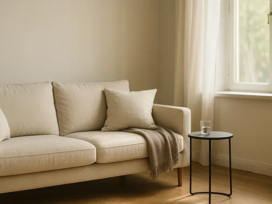 Photorealistic living room showcasing non-toxic furniture: oak-toned sofa in natural linen, powder-coated side table, and open window with sheer.