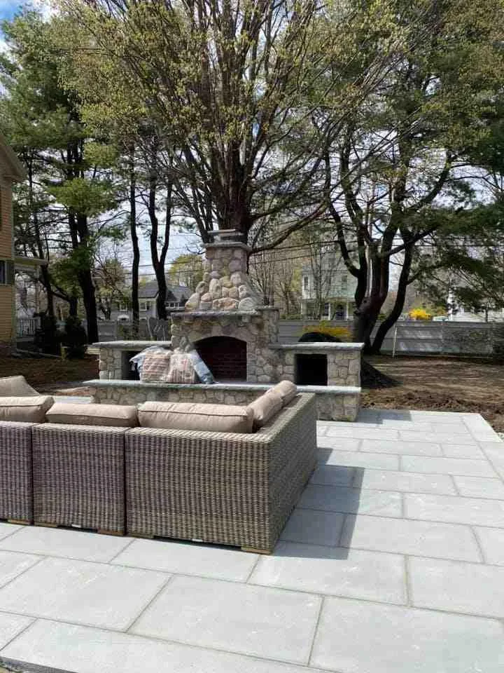 Modern outdoor living space with patio seating, fire feature, and lush planting