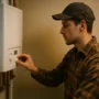 Licensed HVAC technician replacing a residential gas boiler; verifying flue joints and gas connections during commissioning