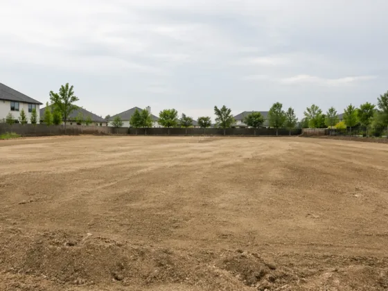 cleared residential lot prepared for home construction in a suburban neighborhood