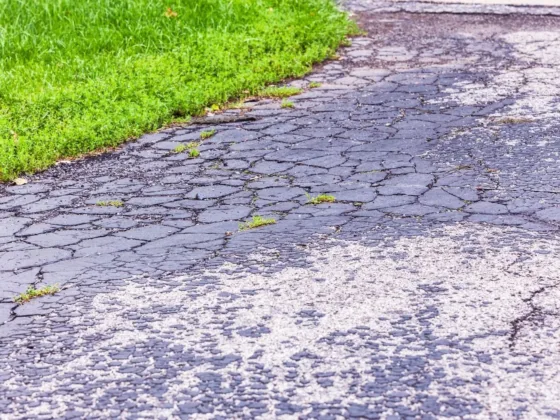 Cracked asphalt driveway showing alligator cracking and surface deterioration caused by aging and weather exposure