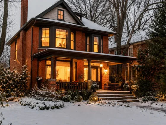 Classic double-brick older Ontario home showing winter energy efficiency and cozy indoor lighting