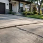 Uneven concrete driveway with a sunken slab outside a modern suburban home