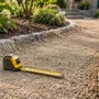 Landscaping measuring tape resting on crushed granite aggregate spread over a prepped garden path base